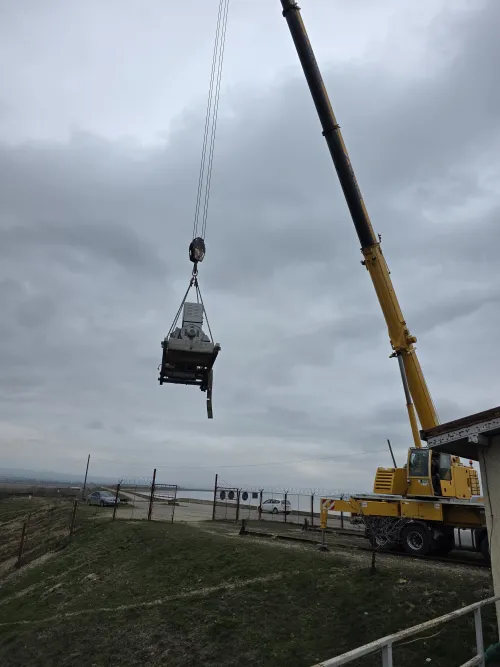 Macara mobilă cu cârlig coborât, pregătită de ridicare pe câmp.